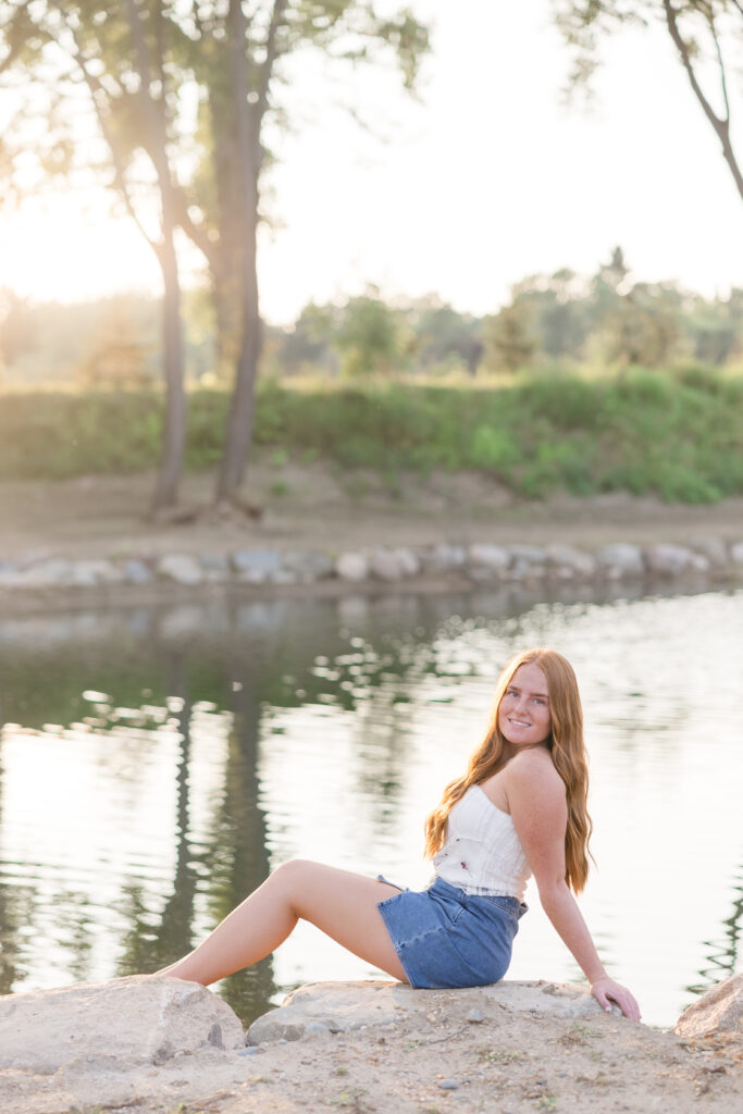 Senior girl in a white dress standing in a lavender field in Mid Michigan during golden hour.